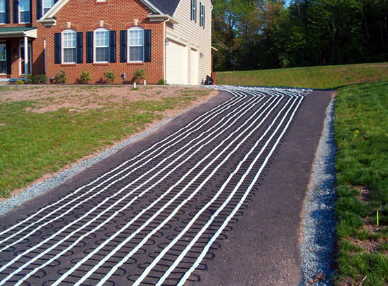 An asphalt driveway being retrofitted with a radiant heat snow melting system.